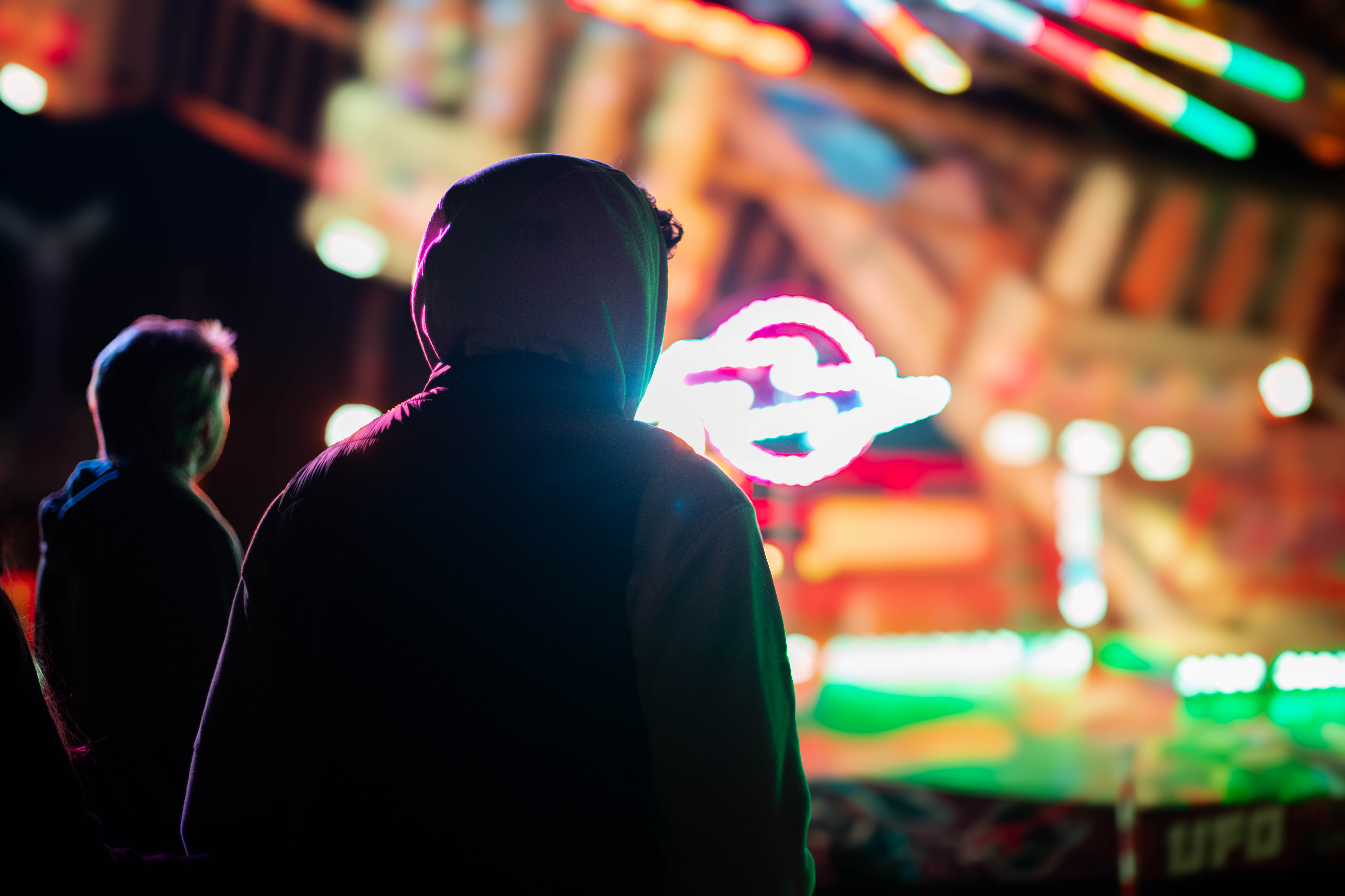 Photo de deux personnes de dos devant une attraction de fête foraine
